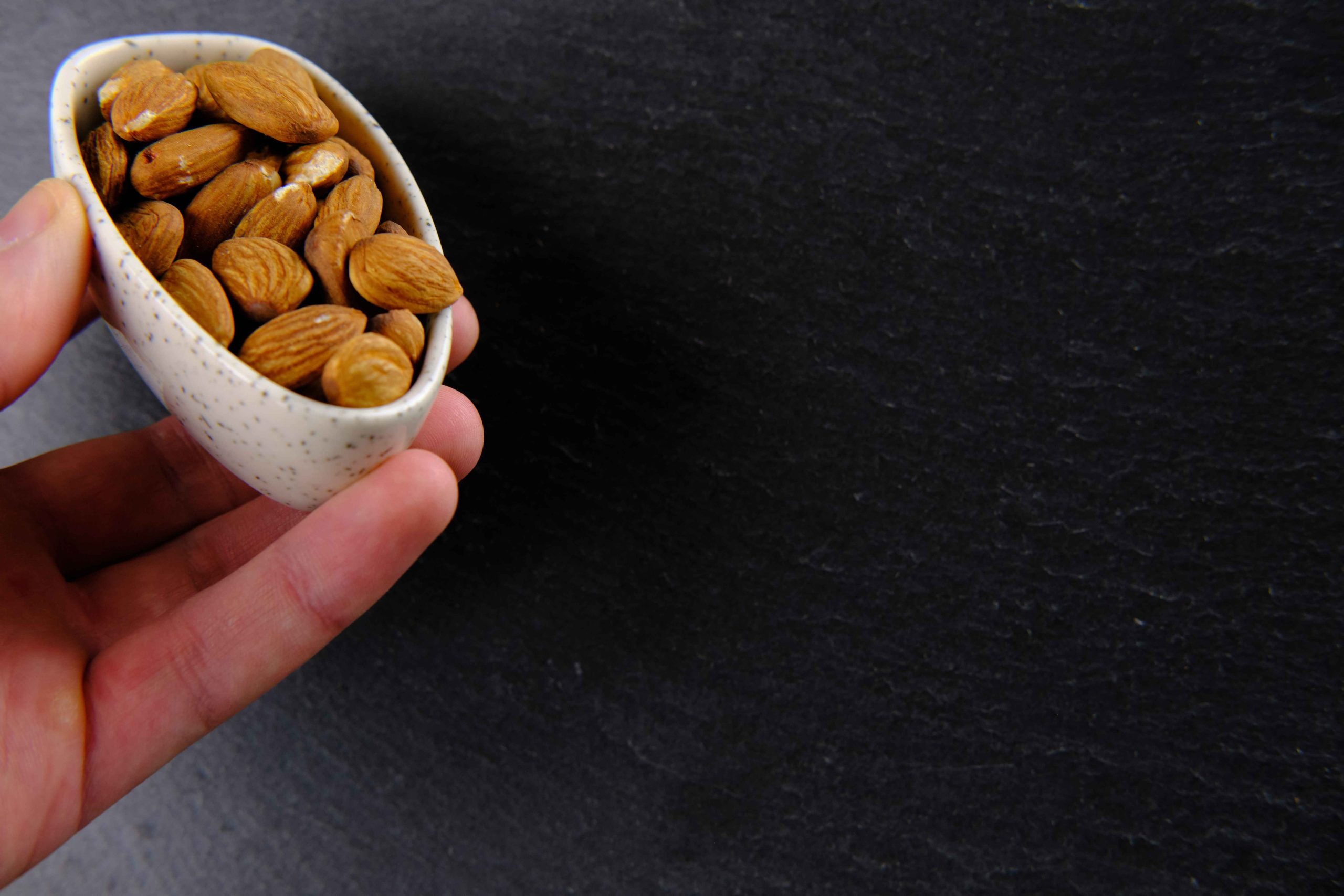 (ilustrasi seseorang konsumsi kacang almond, sumber : freepik)