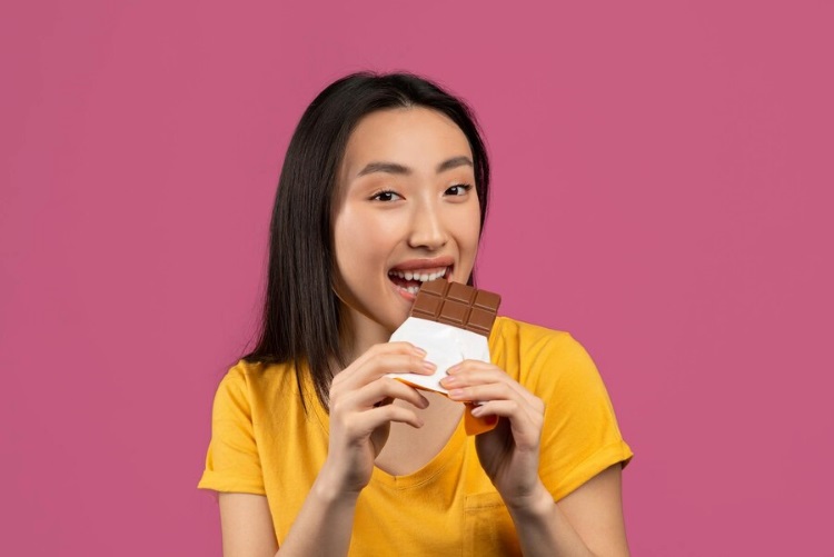 (Ilustrasi seseorang mengonsumsi cokelat, Sumber: Freepik)